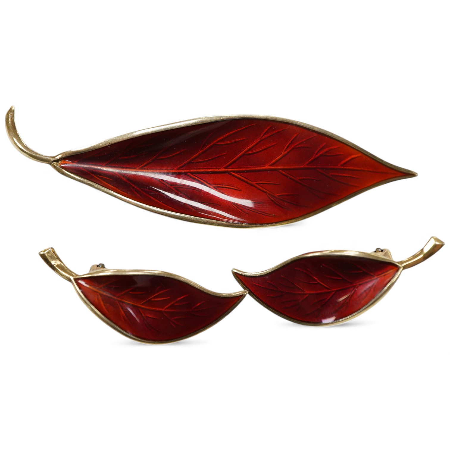 A Norwegian gilt white metal and red enamel demi parure, by David Andersen, comprising a leaf shaped brooch, 65mm and a pair of matching ear clips.